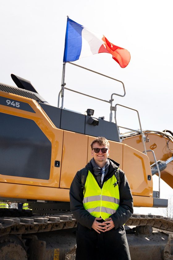 Nicolas Charton devant une pelle, drapeau français en arrière plan